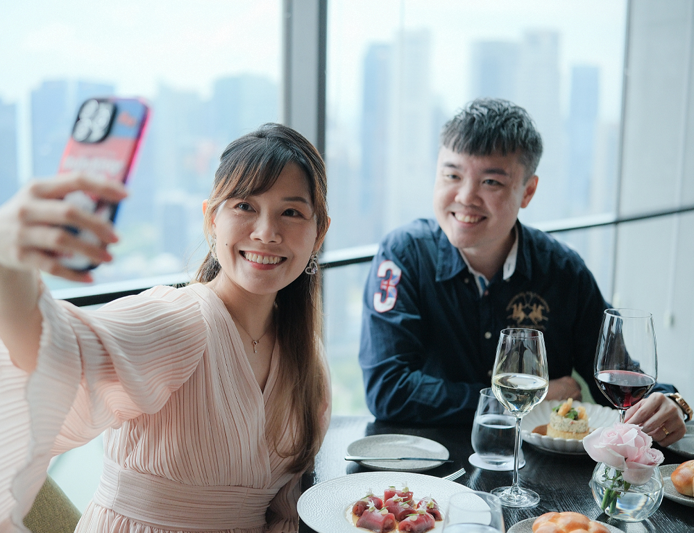 Xinli enjoying a discounted restaurant meal while taking a selfie, showcasing Accor Plus membership benefits.